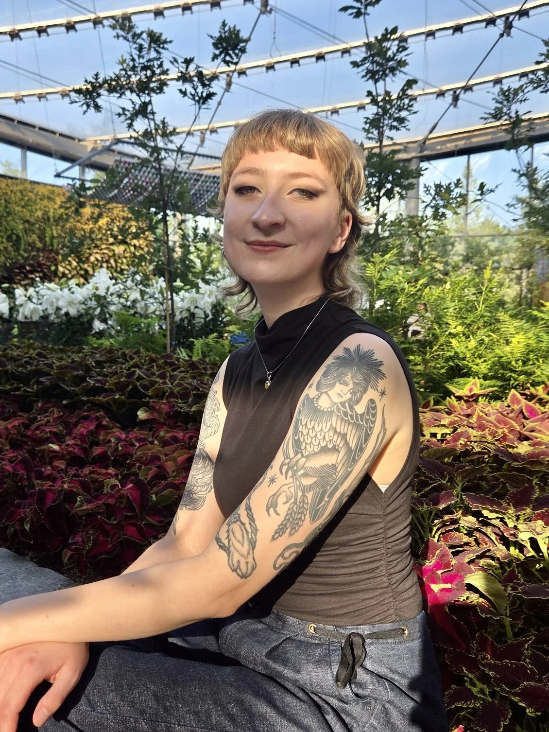 Peyton Lynch, apprentice artist, photographed among greenhouse botanicals